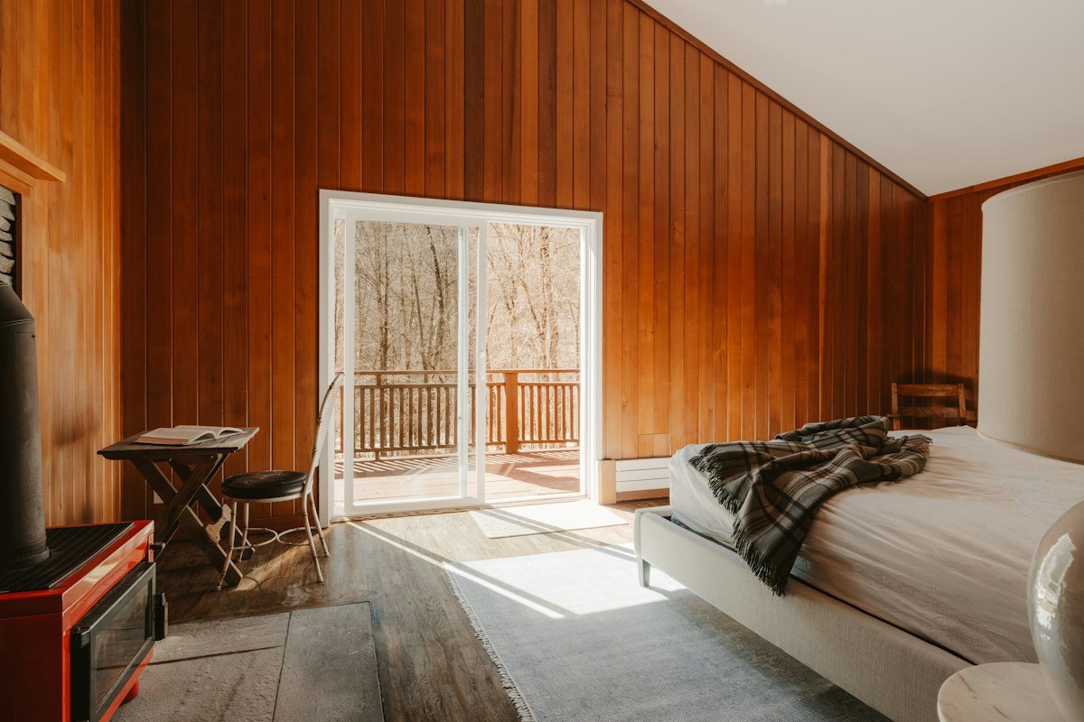 Timber-panelled room opening onto a balcony